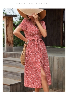 Détail de la robe rouge à fleurs, col en V, lien à la taille et fente latérale