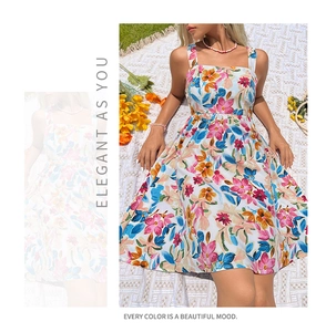 Detail of square neck summer dress with vibrant floral print on outdoor picnic background