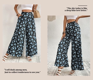 Detail of high-waisted wide-leg trousers featuring blue floral print on black fabric