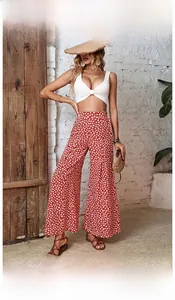 Detail of high-waisted red floral wide-leg trousers with boho summer vacation style