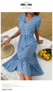Detail of light blue floral summer dress with V-neck and ruffle hem on beach picnic mat