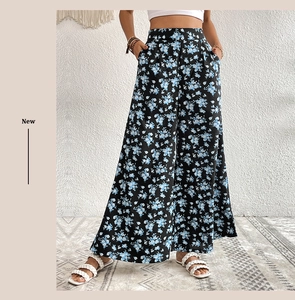 Detail of high waisted wide leg trousers featuring a blue floral print and side pockets