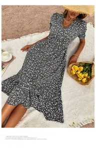 Close-up of V-neck floral dress with orange and white patterns on dark blue fabric