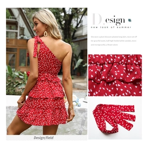 Dettaglio dell'abito estivo rosso monospalla con cuori bianchi e balze a balze multistrato