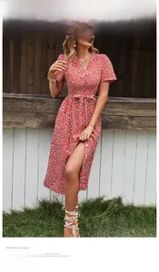 Détail de robe fleurie rouge avec décolleté en V, manches bouffantes et fente haute