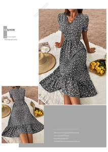 Detail of floral print summer dress with ruffled hem and vintage puff sleeves on beach