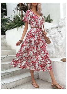 Detail of red floral midi dress featuring V-neckline and ruffled tiered skirt design