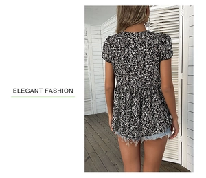 Detail view of floral babydoll top with white petal print on black fabric and ruffled hem