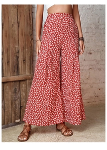 Detail of red floral high-waist wide-leg pants with white flower print on soft fabric