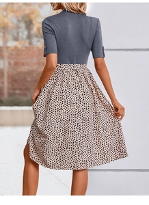 Détail du haut en tricot gris avec boutons dorés et jupe évasée à motif léopard