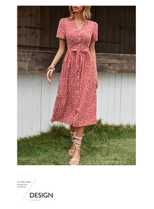 Détail d'une robe fleurie rouge avec col en V, boutons et ceinture à la taille