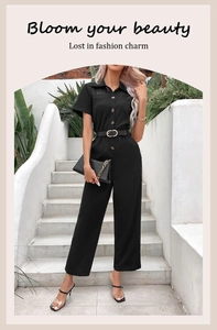 Detail of black jumpsuit showing lace patchwork, button placket and matching waist belt