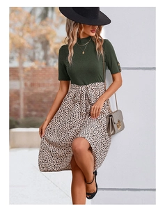 Détail du haut en tricot vert avec boutons dorés et jupe léopard avec ceinture