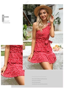 Dettaglio vestito rosso monospalla con stampa a cuori e balze a strati sull'orlo