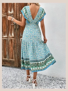 Détail d'une robe longue fleurie avec col en V profond et volants sur les épaules