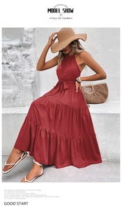 Detail of red tiered halter maxi dress featuring a matching waist tie and pleated skirt