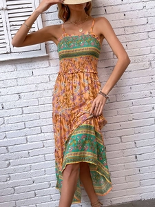 Robe bohème fleurie orange avec haut froncé, bretelles fines et jupe à plusieurs niveaux