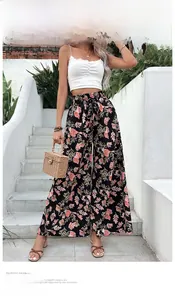 Detail of high-waisted floral wide-leg trousers with elastic drawstring and summer print