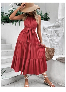 Detail showing the tiered ruffle hem and waist tie of a dark red halter maxi dress