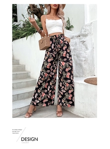 Detail of high waisted floral wide leg trousers featuring pink flower print on black