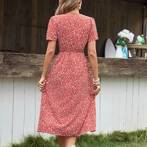 Robe midi rouge à fleurs avec fente, vue de dos dans un décor d'été en plein air