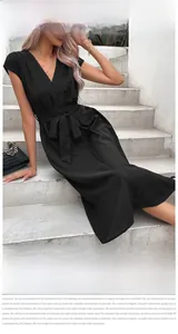Detailed close-up of a black V-neck short sleeve midi dress with waist tie on a model