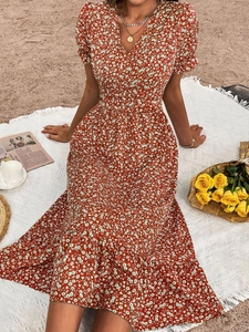 Red floral summer dress with puff sleeves and V-neckline shown in beach setting