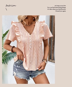 Detail of pink chiffon blouse with gold polka dots and ruffle V-neckline accents