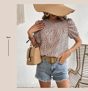 Détails du col froncé et des manches bouffantes sur une blouse rose à cœurs