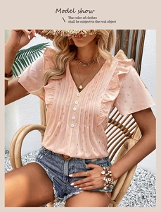 Detail of pink chiffon blouse showing ruffled V-neck and golden foil droplet patterns