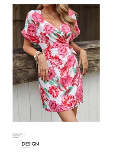 Detail of V-neck wrap dress featuring pink floral prints and elegant tiered jewelry accessories