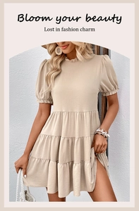 Detail view of beige tiered summer dress with puff sleeves and ruffled round neckline