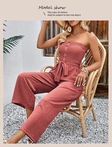 Detail of red-brown strapless wide-leg jumpsuit with decorative buttons and waist tie