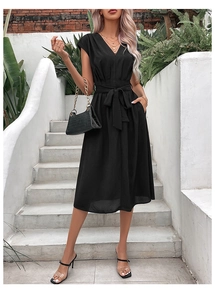 Detail view of the black V-neck dress with adjustable waist tie and textured fabric