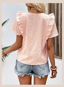 Detail of pink chiffon top with ruffle sleeves and gold dot patterns on model back