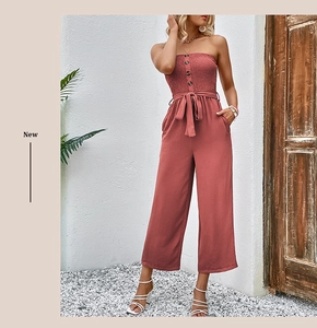 Detail showing elastic smocked bodice and decorative buttons on pink tube jumpsuit