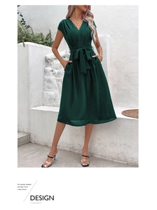 Detail view of dark green V-neck midi dress featuring waist tie and side pockets
