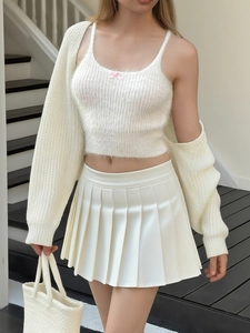 Set top corto in maglia bianca e cardigan con fiocco rosa e gonna a pieghe