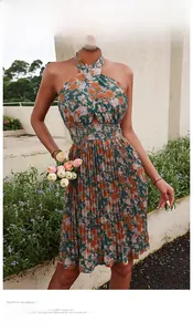 Detail of floral halter neck dress with waist cut-outs and pleated hem in dark green