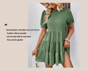 Detail of sage green tiered mini dress featuring puff sleeves and ruffled round neckline