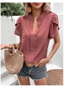 Detail of elegant V-neck short sleeve blouse in pink chiffon with ruffled flutter shoulders