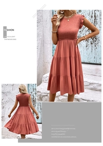 Détail d'une robe corail sans manches avec buste froncé et volants aux épaules