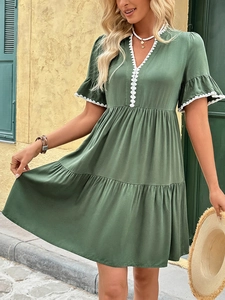 Detail of army green V-neck dress with white scalloped lace edges and ruffled sleeves