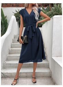 Detail of the navy blue V-neck midi dress with waist tie and pleated shoulder accents