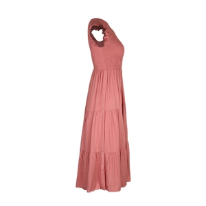Détail du bustier froncé et de la jupe à volants rose fané sur une robe d'été