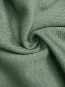Close-up of sage green twill fabric showing detailed weave and soft texture on the dress