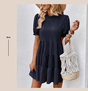 Detail of navy blue tiered dress with ruffled round neck and lantern short sleeves