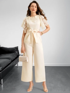 Detail of elegant lace patchwork on sleeve and waist tie of ivory wide leg jumpsuit