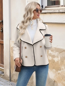 Detail of white double-breasted coat with black contrast piping and lapel collar