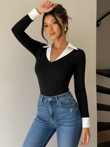 Close-up of contrast collar and cuffs on a black long sleeve bodysuit for women